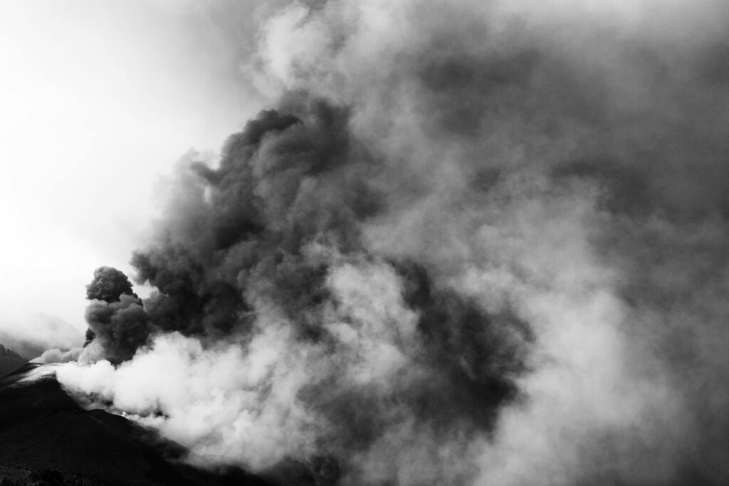 Steam rising from a geothermal power plant under a clear sky, an example of earth-powered crypto solutions.
