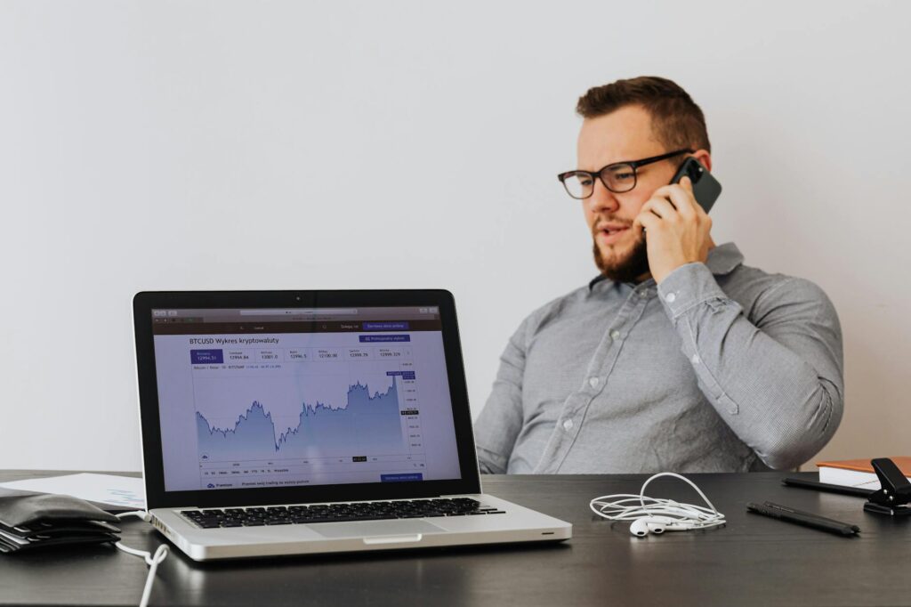 A person's hands holding a smartphone displaying a colorful cryptocurrency price chart.