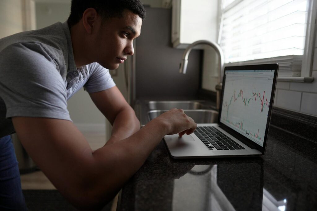 An investor carefully studying cryptocurrency price charts and data on a monitor.