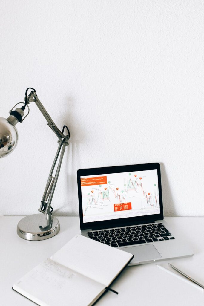 A developer working in a dark room with multiple monitors displaying lines of code.