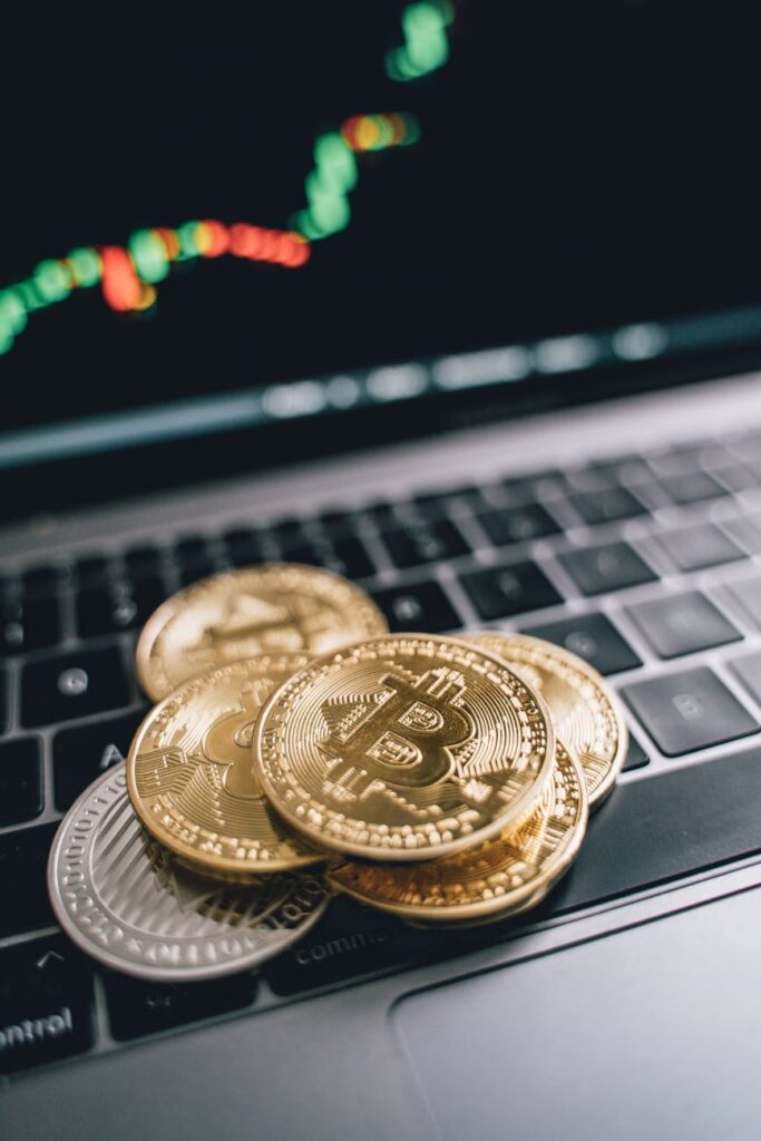 A physical gold Bitcoin coin resting on a green computer motherboard, illustrating the connection between hardware and crypto.