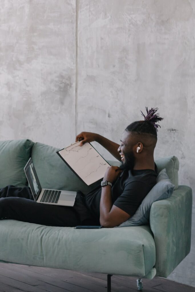 An investor carefully reviewing charts and financial reports on their laptop at a desk.