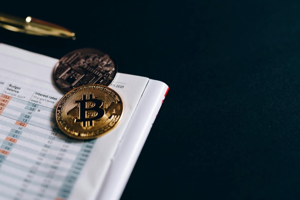 Detailed close-up shot of a physical gold Bitcoin coin, showing its texture and the iconic 'B' symbol.