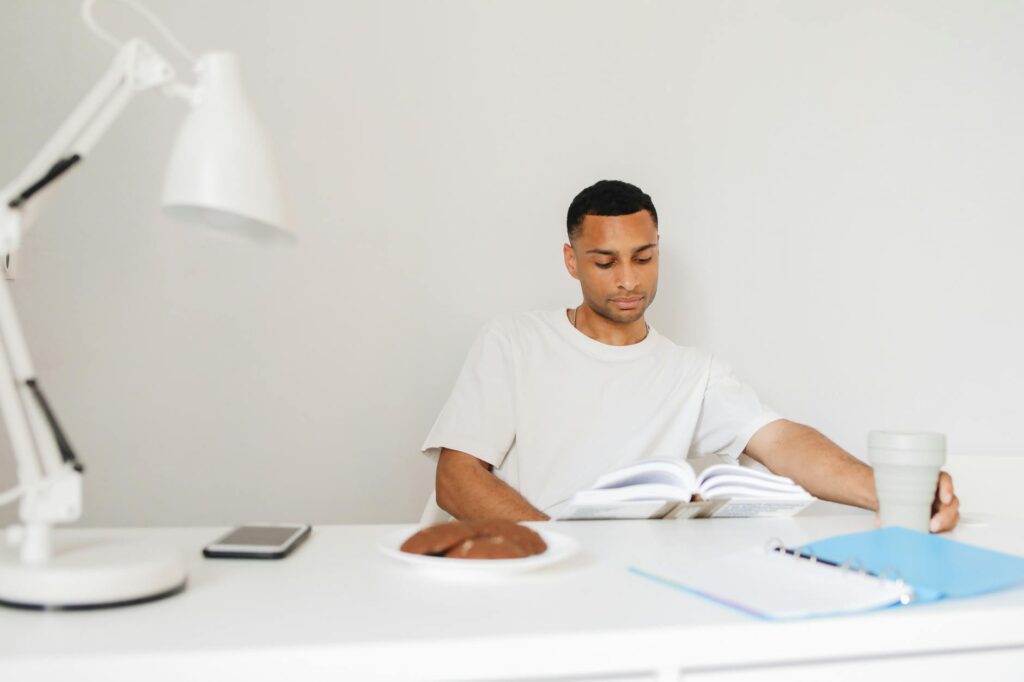 A focused individual studying a book, illustrating the importance of fundamental research and education during a crypto downturn.